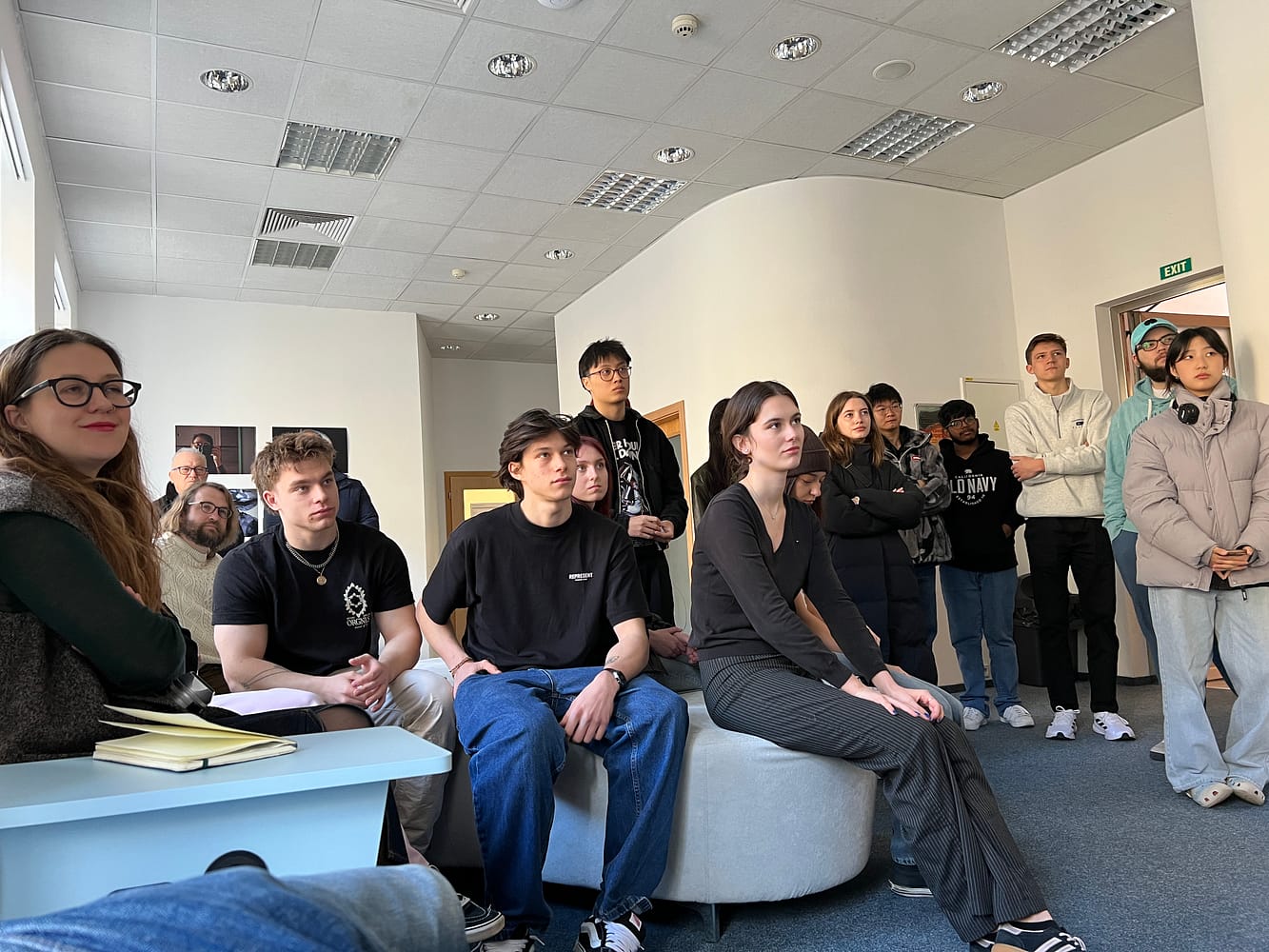 Skupina studentů programu komunikace a média (Bc.) sleduje prezentaci a diskutuje projekty