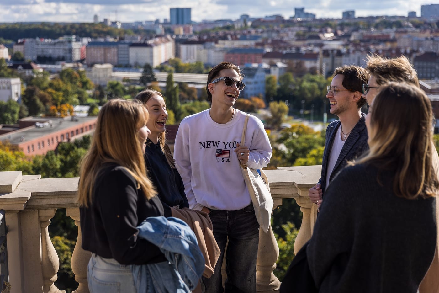 university students in Prague talking outdoors with city view during psychology studies