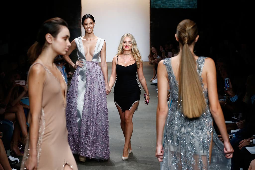Models presenting a fashion collection on a runway, showcasing the relationship between fashion design, marketing, and fashion business management.