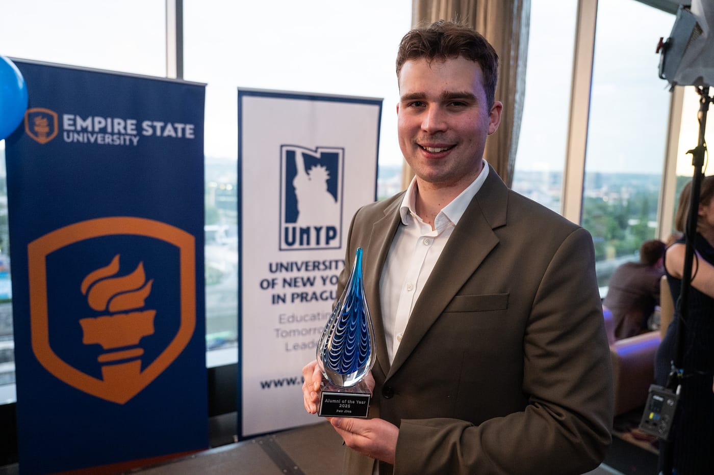 The winner of the UNYP Alumni of the Year Award poses with the prize.