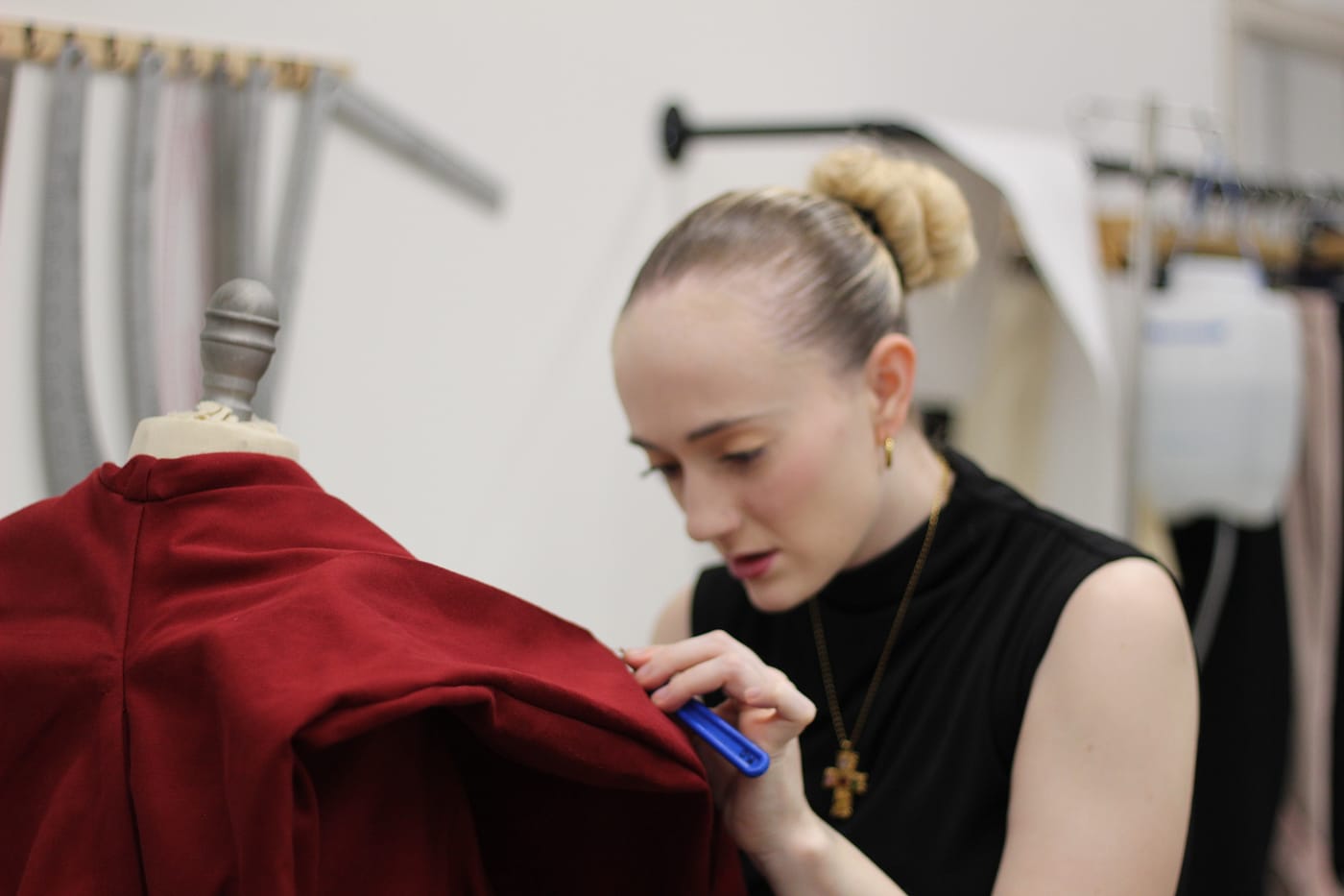 Fashion design student carefully working on a garment prototype, demonstrating the creative and product development process in the fashion industry.