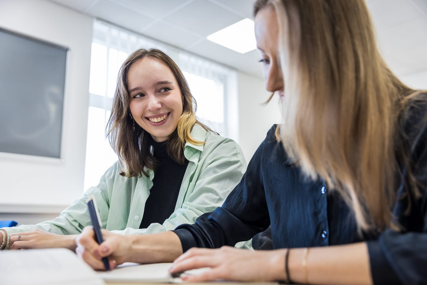Two UNYP students work together on an assignment modeled after the American university learning model.